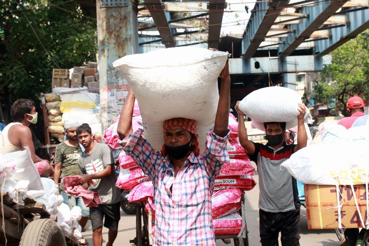Workers carry sacks filled with sugar to load them onto a supply truck at a wholesale market after the government eased restrictions imposed as a preventive measure against the COVID-19 coronavirus, in Kolkata, India on June 01,2020.