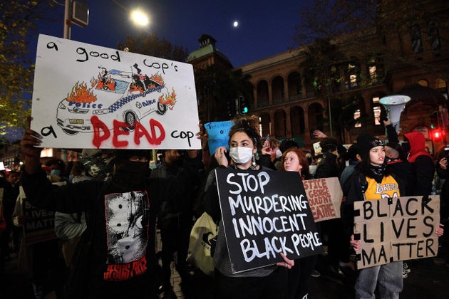 Protesters hold up placards during a rally for justice in Sydney on June 2, 2020, against the deaths of members of the Aboriginal community in Australia and the death of George Floyd.