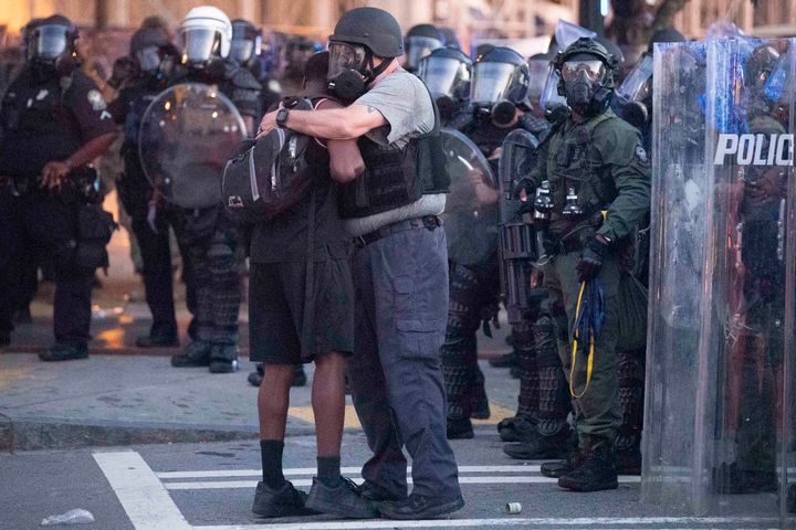 Θερμή αγκαλιά αστυνομικού και διαδηλωτή στην Ατλάντα. (AP Photo/John Bazemore)