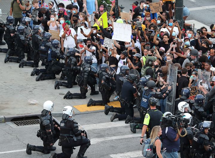 Σε ένδειξη αλληλεγγύης, οι αστυνομικές δυνάμεις της Ατλάντα γονατίζουν μπροστά στους διαδηλωτές. (Curtis ComptonAtlanta Journal-Constitution via AP.)