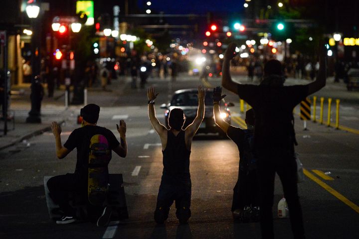 Protesters kneel on May 31 during the fourth consecutive day of protests in Denver following the death of George Floyd.