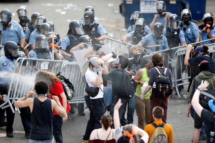 Police spray mace at protesters to break up a gathering near the Minneapolis Police third precinct on May 27 after a white po