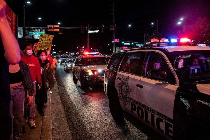 Police officers look outside their car window as people march in a Black Lives Matter rally in downtown Las Vegas on June 1.