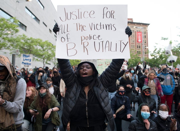 A anti-police brutality protester hold a sign during a demonstration calling for justice in the death of George Floyd and victims of police brutality in Montreal on May 31, 2020.