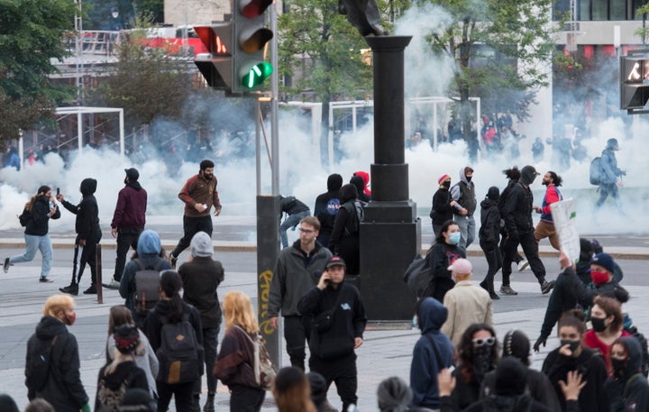 Protesters run from police during a demonstration calling for justice in the death of George Floyd and victims of police brutality in Montreal on May 31, 2020.