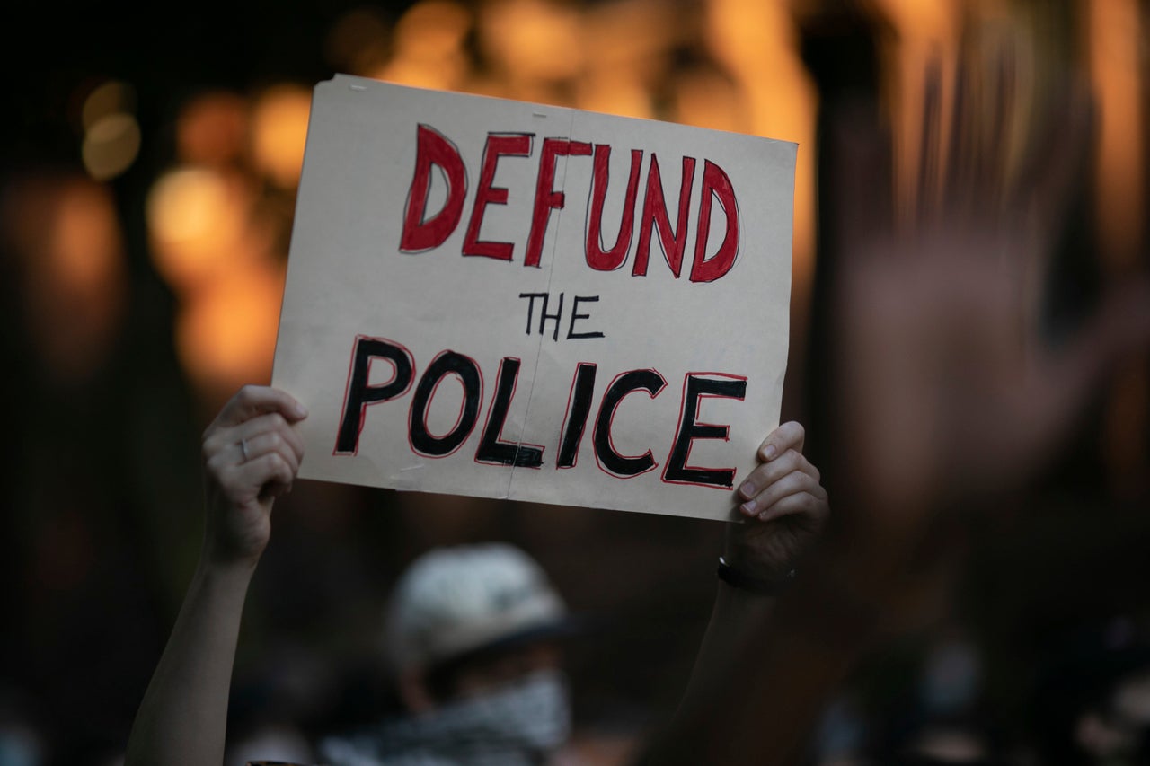 Activists carry protest signs during a march in the Prospect Heights section of Brooklyn on Sunday over the May 25 police killing of George Floyd in Minneapolis.