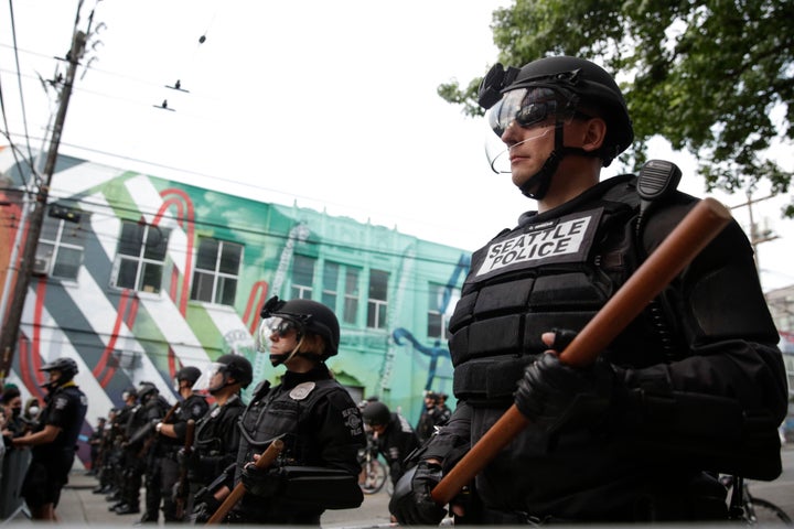 Seattle Police stand guard outside a precinct on Monday as people In Seattle joined in the nationwide protests over the killi