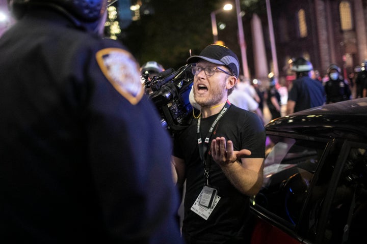 Associated Press videojournalist Robert Bumsted reminds a police officer that the press are considered “essential workers" and are allowed to be on the streets despite a curfew, on June 2, 2020, in New York. 