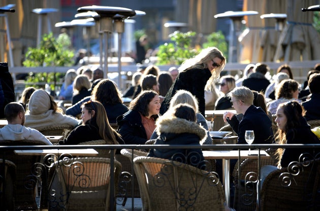 People enjoy the sun at an outdoor restaurant, despite the continuing spread of the coronavirus disease in Stockholm, Sweden March 26.