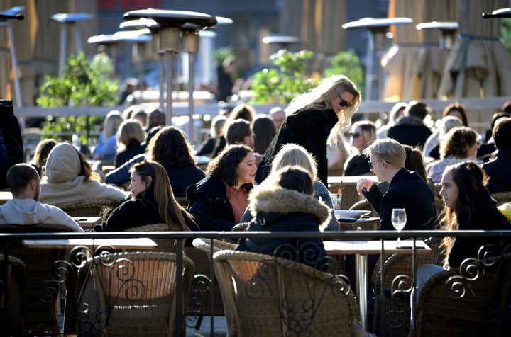 People enjoy the sun at an outdoor restaurant, despite the continuing spread of the coronavirus disease in Stockholm, Sweden March 26.