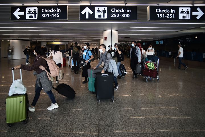 Travelers walk across a terminal at Rome's Fiumicino airport on June 3, 2020, as airports and borders reopen for tourists and residents are free to travel across the country.