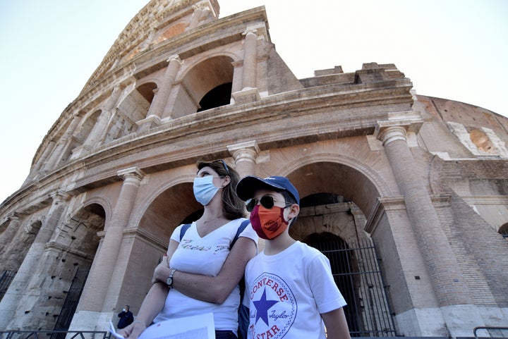 People wearing face masks visit the Colosseum on June 1, 2020, in Rome, after three months of closure due to coronavirus lockdown measures.