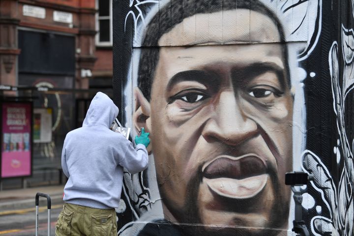 Street artist Akse spray paints a mural of George Floyd in Manchester 