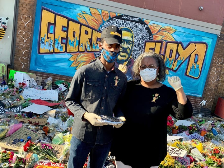 Volunteers Matthew and Andrena Seawood, son and mother, pose in front of artwork honoring George Floyd in Minneapolis.