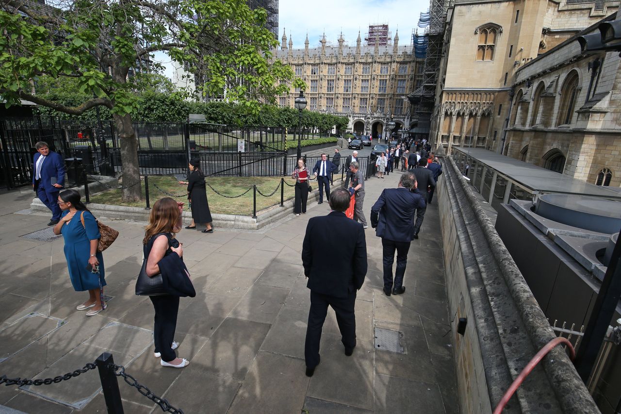 MPs queue outside the House of Commons in Westminster, London, as they wait to vote on the future of proceedings, amid a row over how Commons business can take place safely