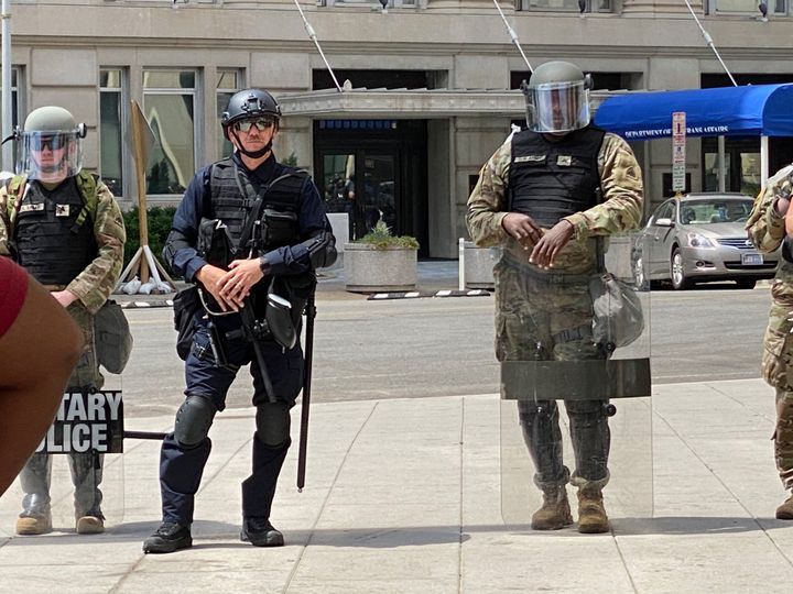A member of federal law enforcement stands among members of the National Guard on Wednesday. Without nametags or ID on uniforms, especially for officers in riot gear, it could be difficult to identify a particular officer in a misconduct complaint.