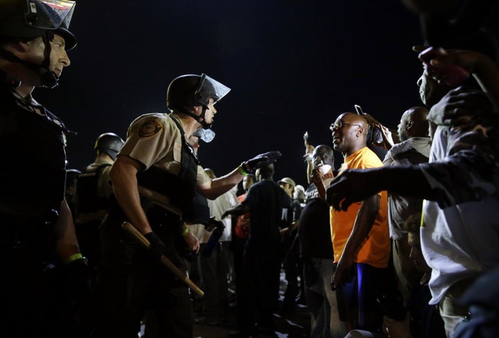 Officers and protesters face off on Aug. 10, 2015, in Ferguson, Mo., after a protest marking the anniversary of Michael Brown's death was punctuated with gunshots.