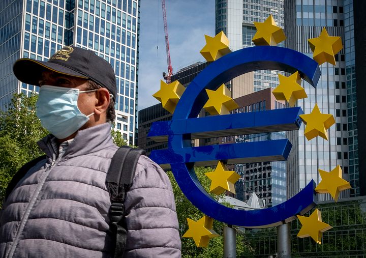 Φωτογραφία αρχείου: 5 Μαϊου 2020. Ενας άνδρας περπτά μπροστά στο γλυπτό με το σήμα του ευρώ, μπροστά από την έδρα της ΕΚΤ στην Φραγκφούρτη. (AP Photo/Michael Probst)