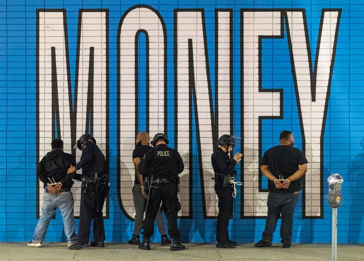 Fully equipped police in Los Angeles make arrests on Monday after a curfew went into effect during demonstrations spurred by the death of George Floyd at the hands of Minneapolis officers.