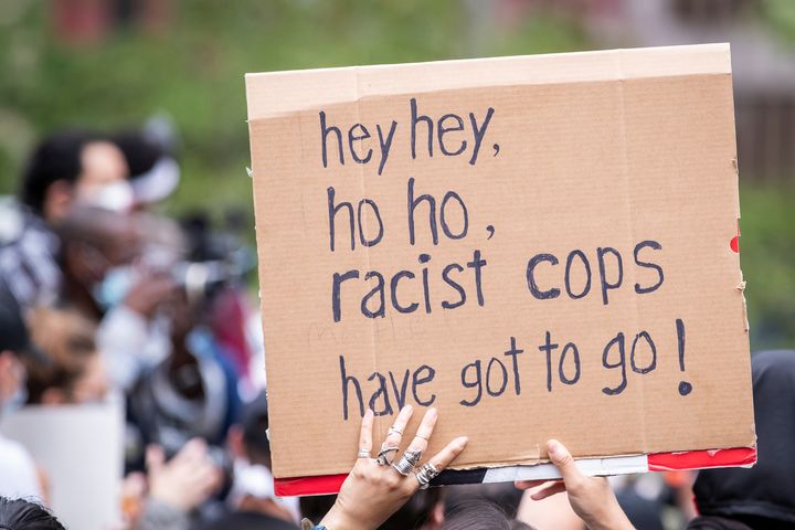 A protester holds a sign that says, "Hey hey, ho ho, racist cops have got to go!" in Manhattan's Foley Square in New York City on June 2, 2020.