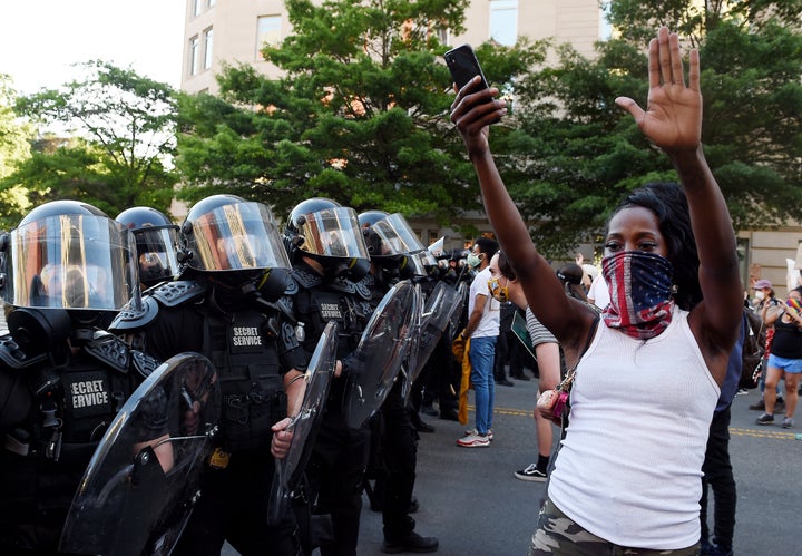 A protester stands, arms in the air, in front of a row of officers during a demonstration near the White House on June 1.