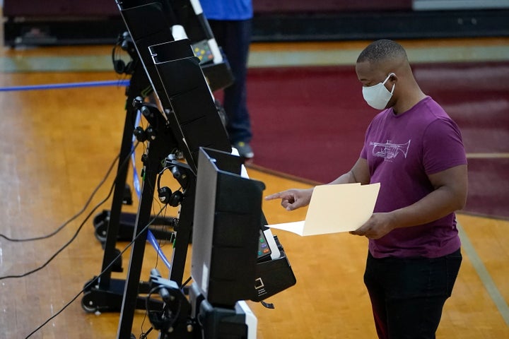 A man votes in Washington, DC's, primary election on June 2, 2020. Many voters had to spend hours waiting in line at polling 