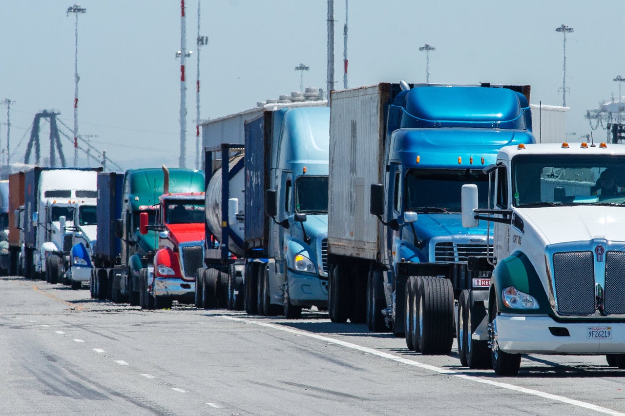 Shipping trucks leave the Port of Oakland on Wednesday in Oakland, California.