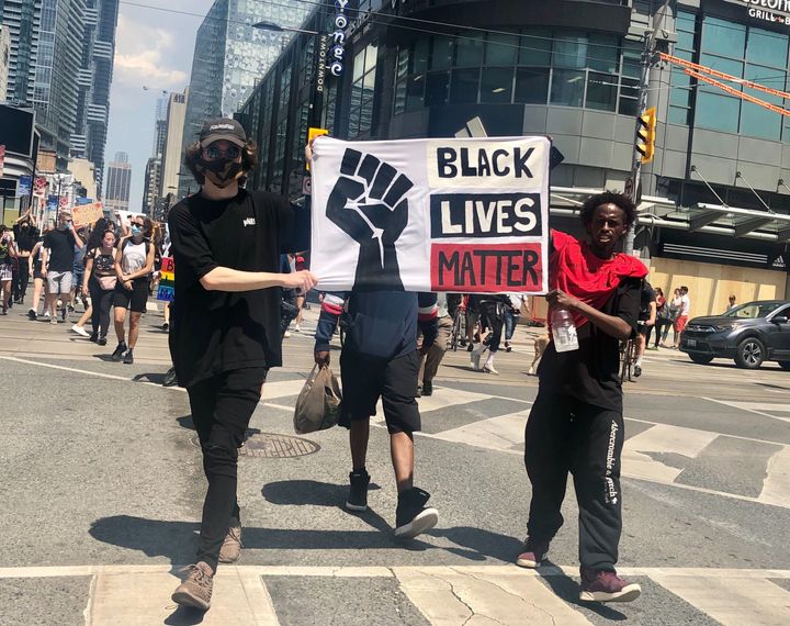 Protesters carry a sign at Toronto's March For Change on Friday.