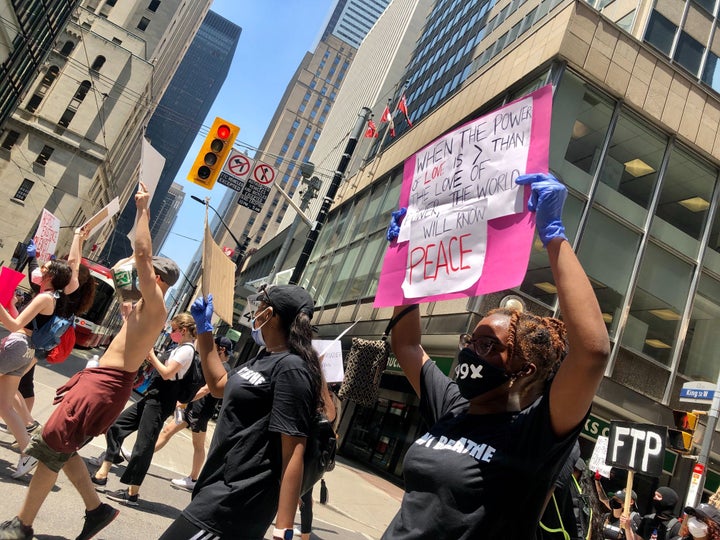 Angelica Martin carries a sign at Toronto's March For Change on Friday.