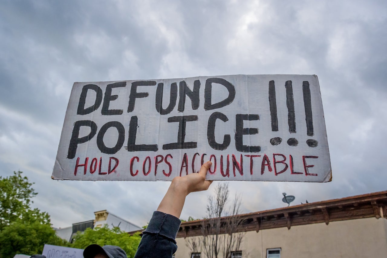 A participant holding a "Defund Police" sign at a protest. Hundreds of protesters flooded the streets of Crown Heights in Brooklyn, New York, to demand the defunding of the police force and to demonstrate against police brutality in the wake of George Floyd's death.