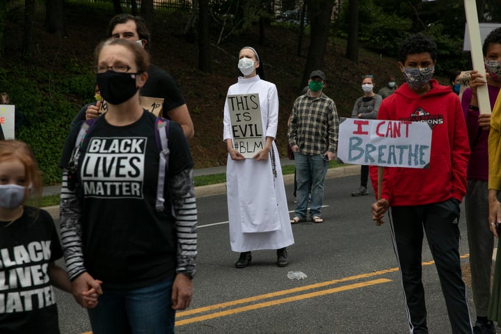 Sister Quincy Howard, center, a Dominican nun, protests the arrival Tuesday of President Donald Trump at the St. John Paul II National Shrine in Washington.