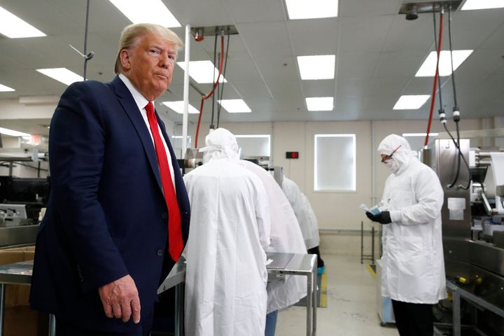 President Donald Trump roams the factory floor at Puritan Medical Products in Guilford, Maine, around suited-up employees working with sterile COVID-19 testing swabs.
