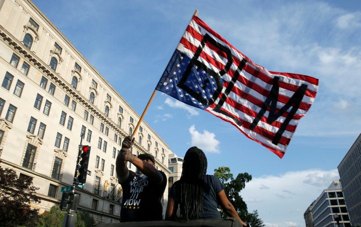 ホワイトハウス付近、逆さの星条旗に書いた「Black Lives Matter」のメッセージを掲げる抗議者、6月6日撮影