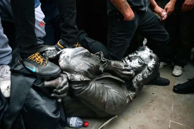 한 시위자가 끌어내려진 동상의 목을 무릎으로 누르고 있다. 브리스톨, 영국. 2020년