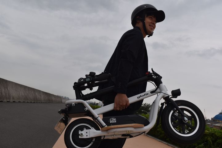 glafit株式会社・代表取締役社長の鳴海禎造さん。バイクは折りたたんで手でも運べる
