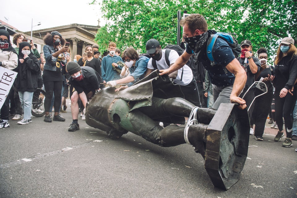 Protesters rolling the statue of slaver Edward Colston towards Bristol's harbour.