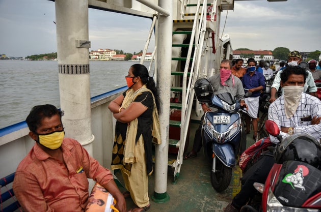People wearing masks travel on a ferry in Kochi, Kerala, May 29,
