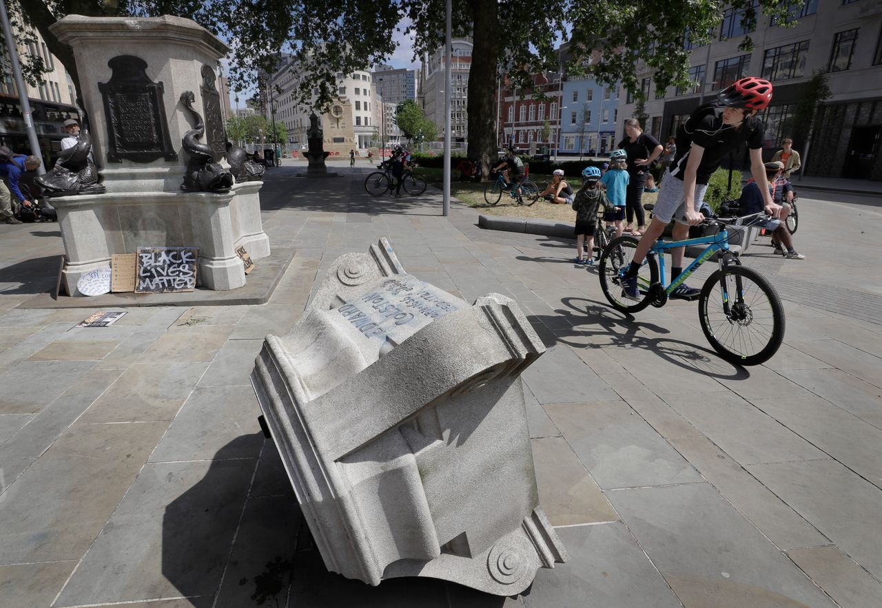 Passers-by look at the pedestal of the toppled statue of Edward Colston on Monday. 