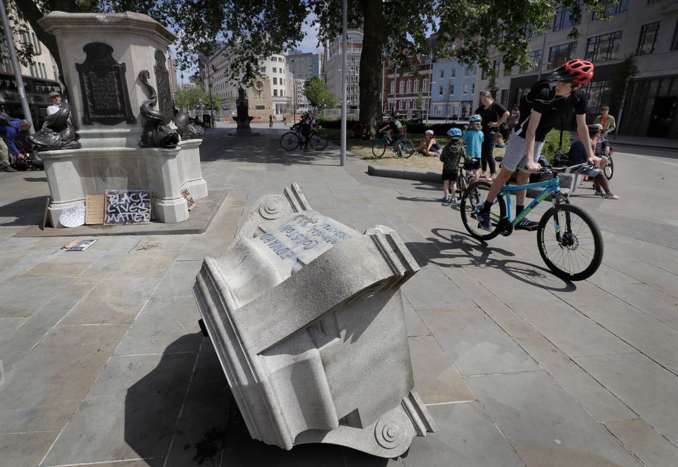 Passers-by look at the pedestal of the toppled statue of Edward Colston on Monday. 