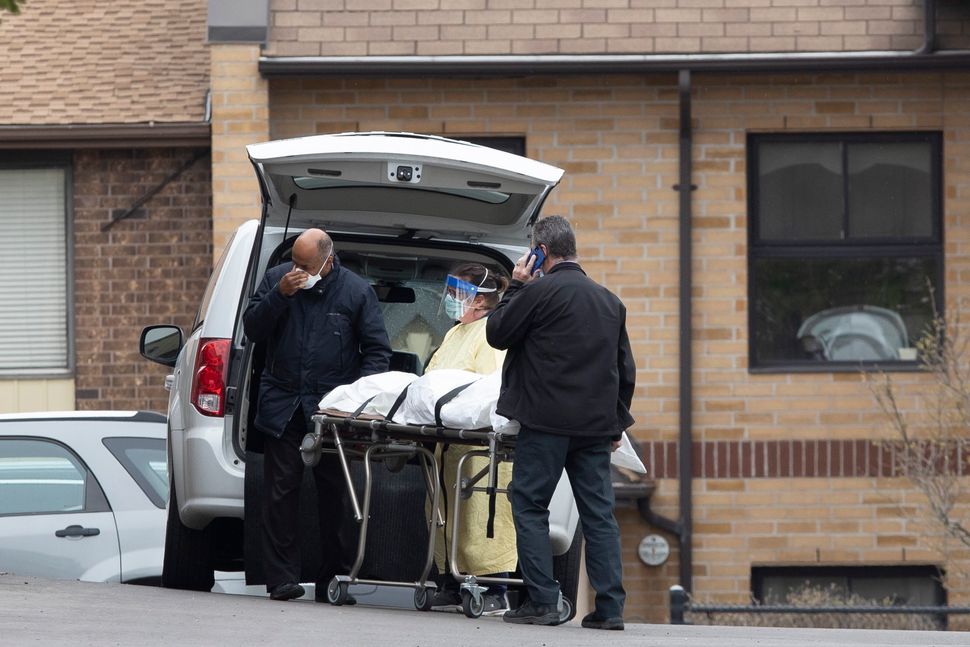 A body is removed from Orchard Villa home in Pickering, Ont. on April 26, 2020. 