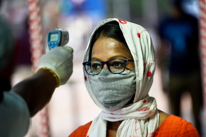 A woman's temperature is checked at a shopping mall in Kolkata on June 8, 2020. 