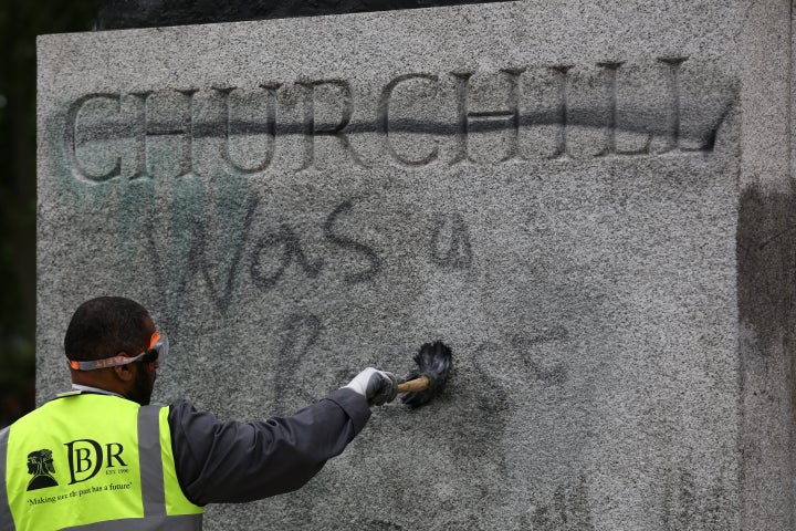 A worker cleans graffiti from the plinth of the statue of Sir Winston Churchill at Parliament Square in London, following a Black Lives Matter protest at the weekend.