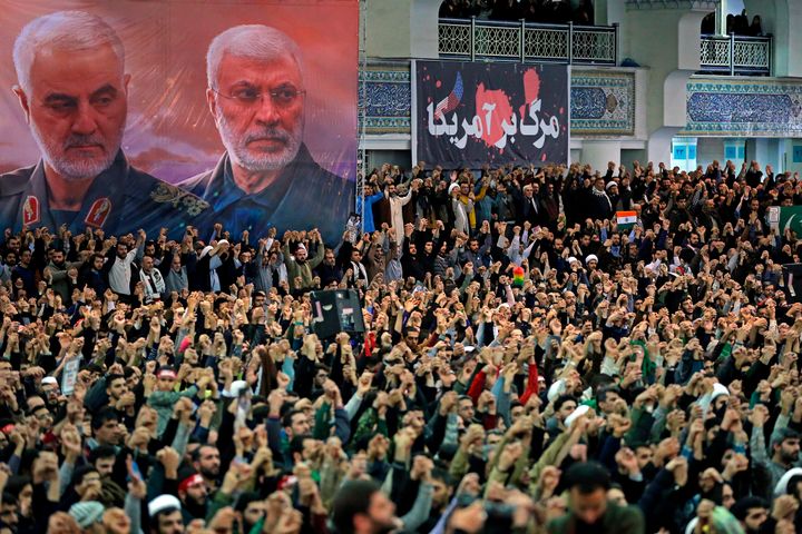 Πιστοί θρηνούν και φωνάζουν συνθήματα κατά τη διάρκεια της προσευχής της Παρασκευής, κάτω από ένα πανό με τη φωτογραφία του Κασέμ Σολεϊμανί (αριστερά) και του Ιρακινού στρατιωτικού διοικητή των Σιιτών μουσουλμάνων, Άμπου Μαχντί αλ Μουχάντι, οι οποίοι σκοτώθηκαν στο Ιράν κατά τη διάρκεια επίθεσης από αμερικανικό drone στις 3 Ιανουαρίου 2020. (Office of the Iranian Supreme Leader via AP)