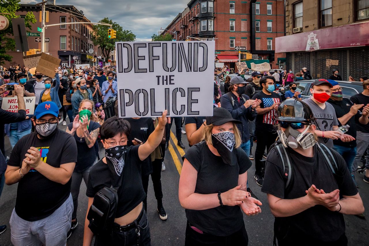 A protester in Brooklyn, New York holds a "Defund the Police" sign at a protest march on June 2, 2020, demanding justice for George Floyd.