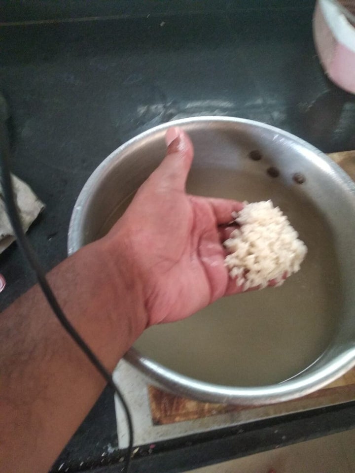 Hotel staff of a budget hotel on relief road in Ahmedabad showing half cooked rice prepared under sunlight.