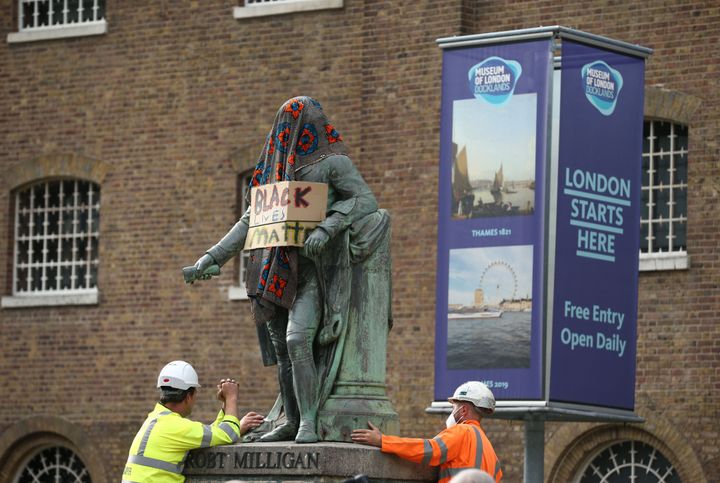 Workers prepare to take down a statue of slave owner Robert Milligan at West India Quay, east London as Labour councils across England and Wales will begin reviewing monuments and statues in their towns and cities, after a protest saw anti-racism campaigners tear down a statue of a slave trader in Bristol.