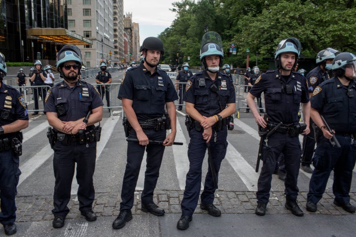 Police officers guard the Trump International Hotel in Manhattan's Columbus Circle as a large demonstration approaches on Jun
