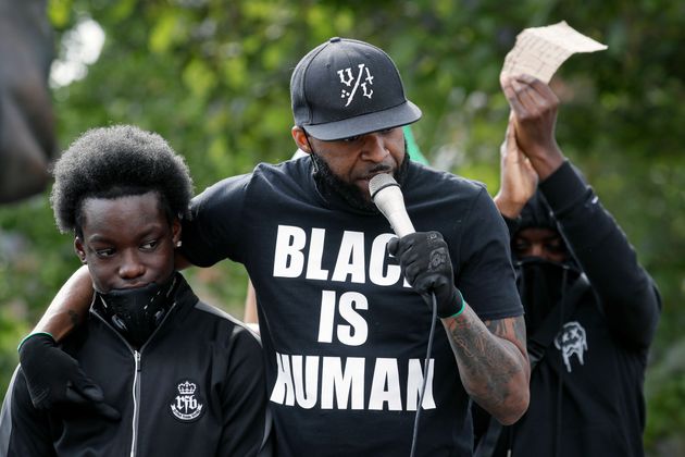 A man addresses gathering demonstrators ahead of a raly in Parliament Square in London, Tuesday, June 9, 2020. The rally is to commemorate George Floyd whose private funeral takes place in the US on Tuesday. (AP Photo/Kirsty Wigglesworth)