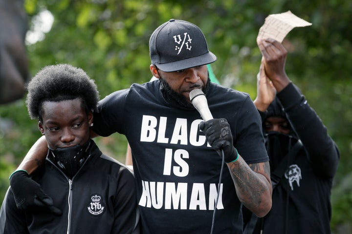 A man addresses gathering demonstrators ahead of a raly in Parliament Square in London, Tuesday, June 9, 2020. The rally is to commemorate George Floyd whose private funeral takes place in the US on Tuesday. (AP Photo/Kirsty Wigglesworth)