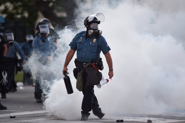 Law enforcement officers stand guard after tear gas is deployed near 47th and Main streets in Kansas City, Missouri, on May 31.